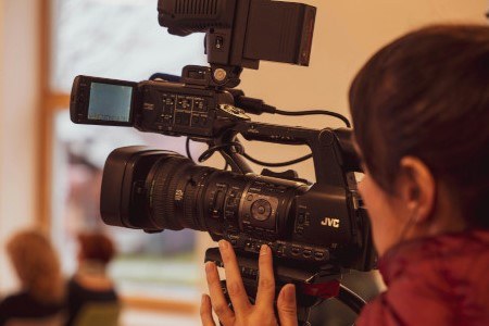 2_2_Video_pexels-vladimirsrajber-450x300.jpg Bild einer Frau, die eine Kamera bedient