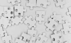 Puzzle Weiße Puzzleteile liegen durcheinander auf einem Haufen