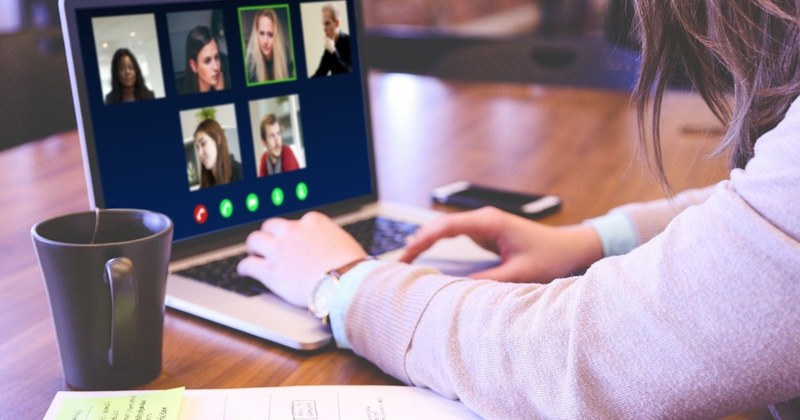 Online-Lehre Eine junge Frau sitzt vor ihrem Laptop und befindet sich gerade in einem Online-Gespräch.