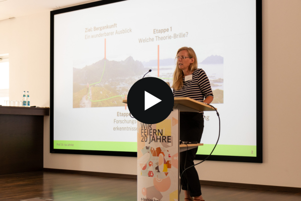 Jubiläumstagung - Keynote Prof. Dr. Isa Jahnke steht vor einem Rednerpult, hinter ihr ist ihre Präsentationsfolie zu sehen.